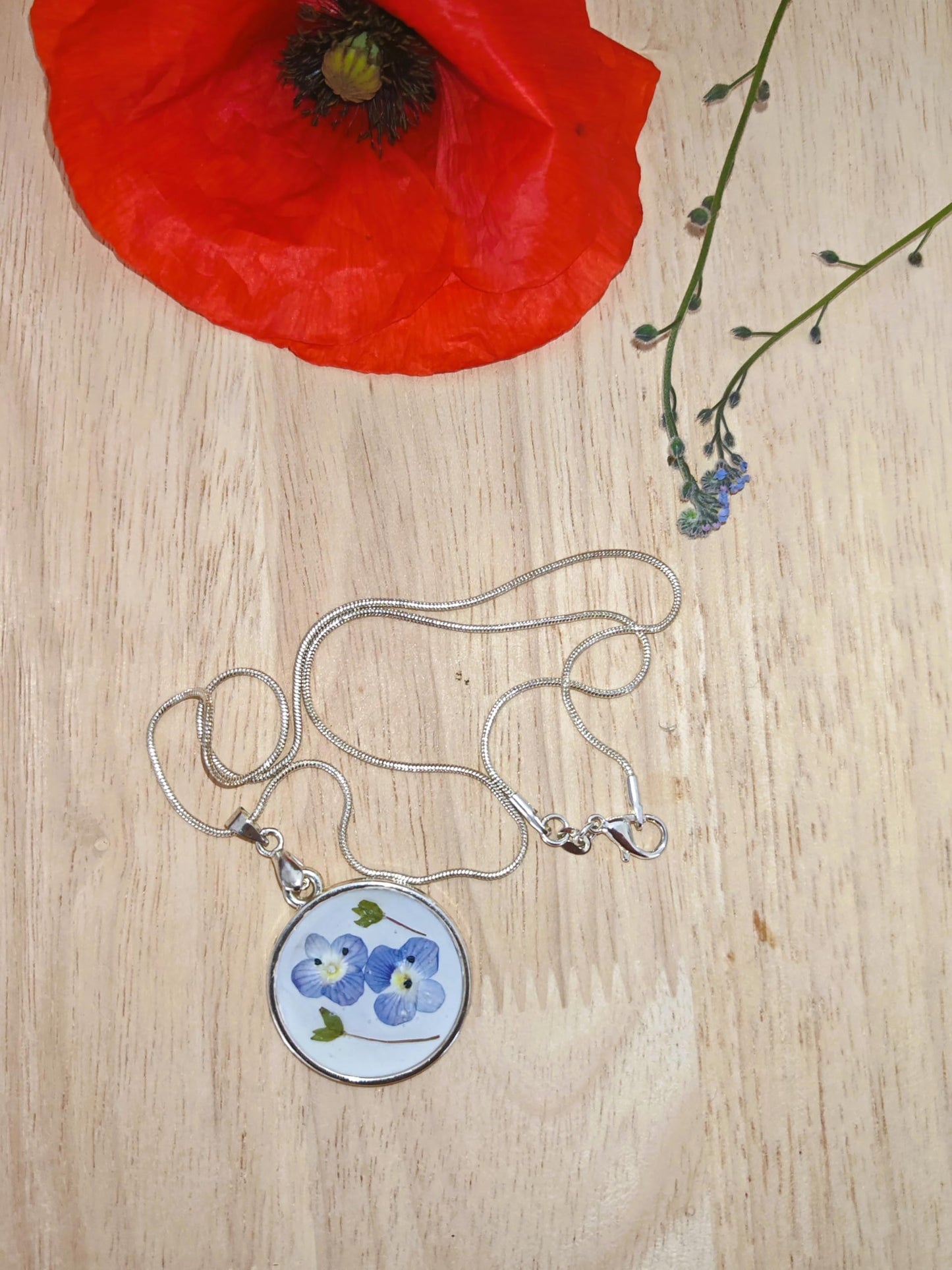S Styles Bijoux, Handmade silver necklace featuring real pressed blue flowers preserved in resin. A unique and elegant gift, perfect for special occasions.